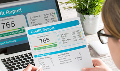 A person holding up their credit report on top of the desk.