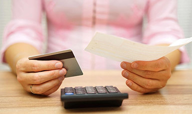 Young woman using a calculator and other hand take a bill