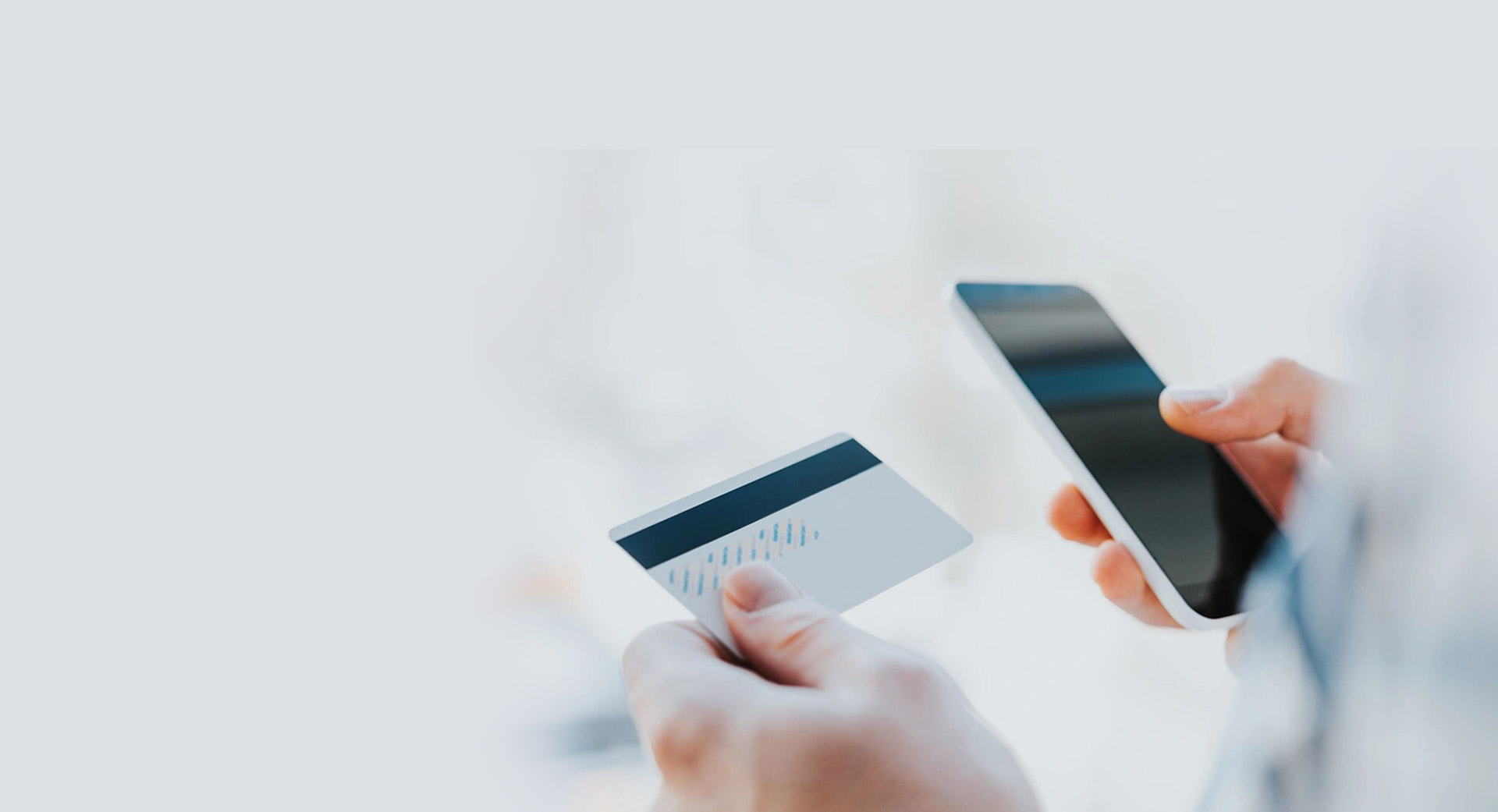 Young man using Phone with credit card in other hand