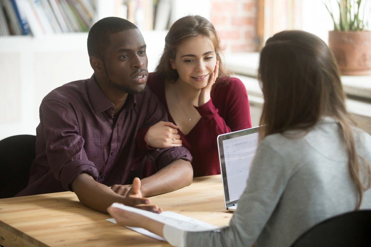 A woman is talking to two men at the table