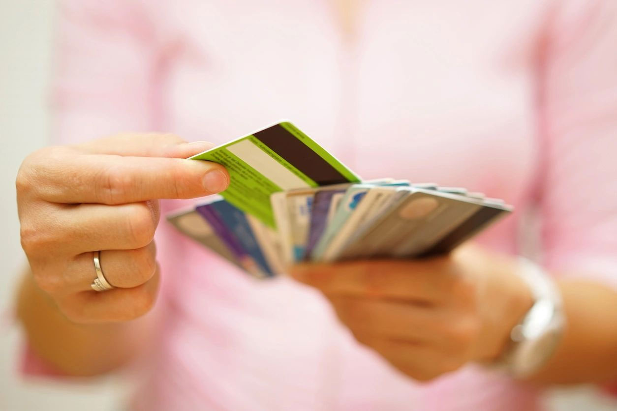 A person holding up two credit cards in their hands.