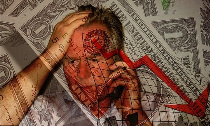 A man with tattoos on his face is looking at the dollar bill.